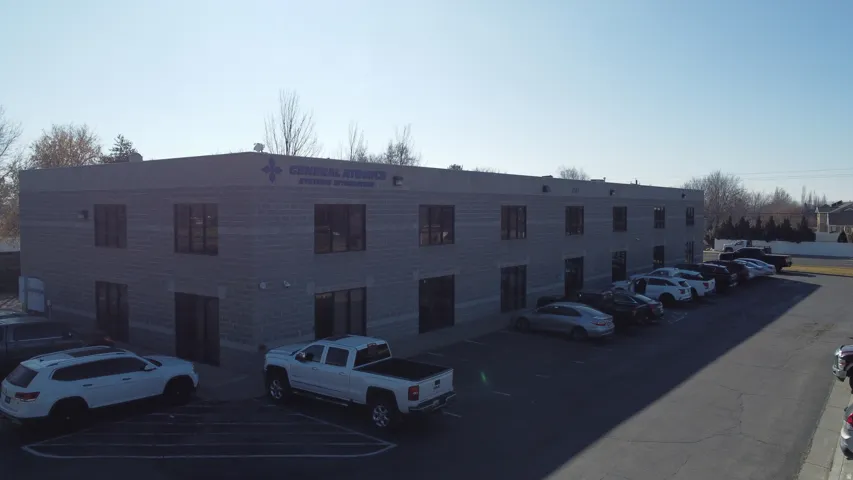 View of apartment building / complex featuring uncovered parking