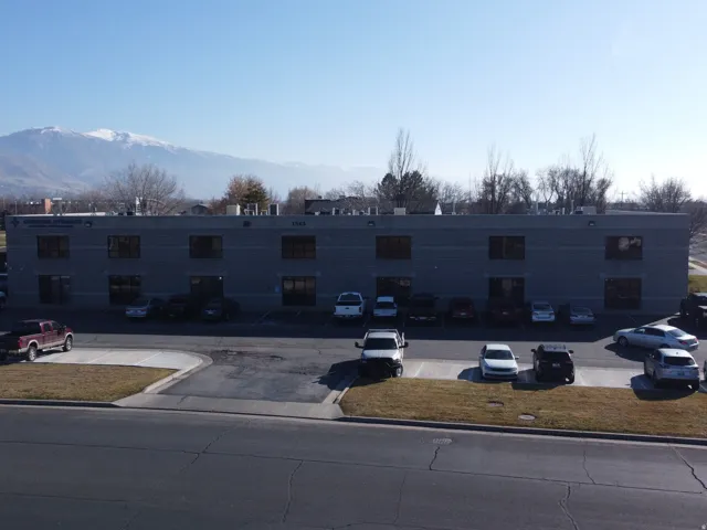 View of building exterior with uncovered parking and a mountain view