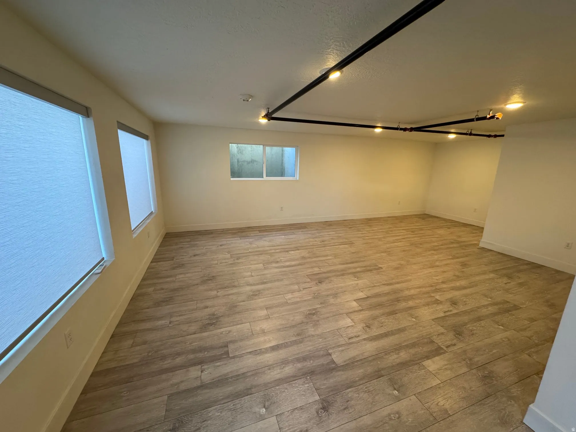 Empty room with light wood-style flooring and a textured ceiling