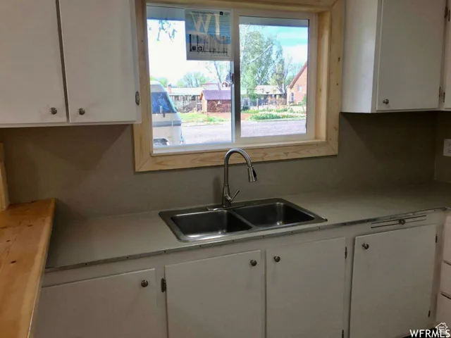 Kitchen featuring light countertops and white cabinets
