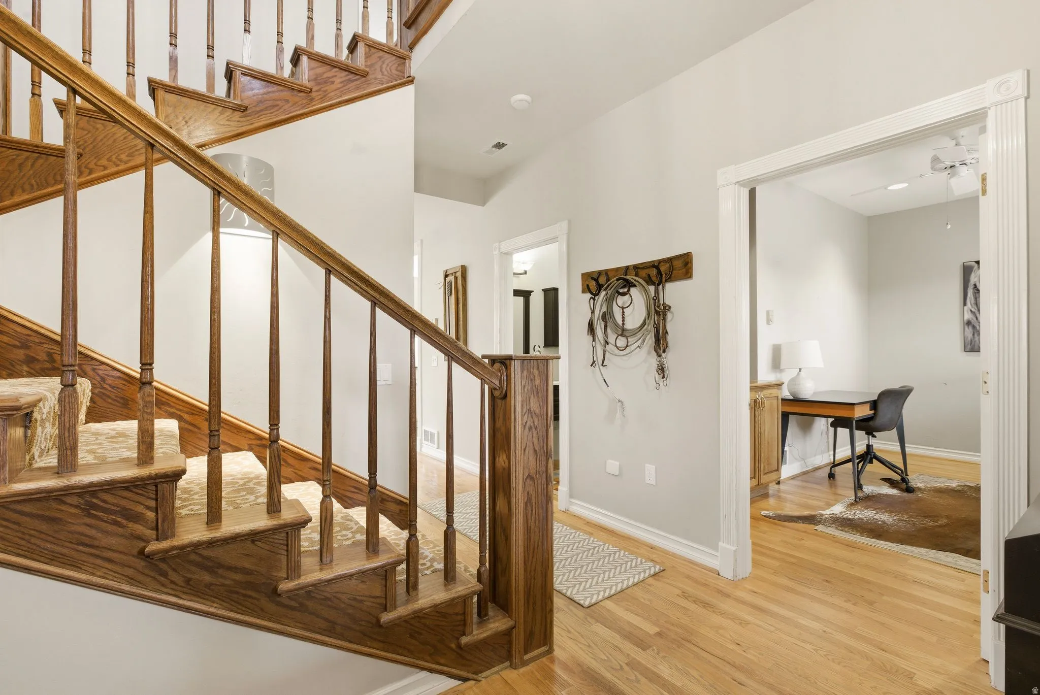Staircase featuring wood finished floors and ceiling fan