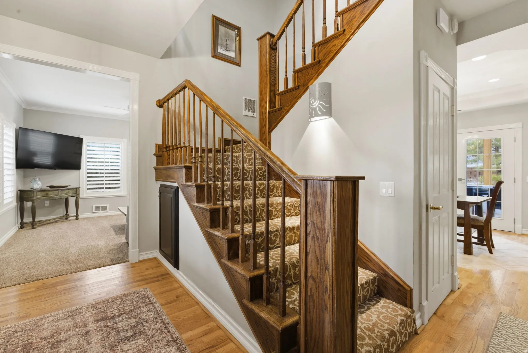 Staircase featuring hardwood / wood-style floors, healthy amount of natural light, ornamental molding, and recessed lighting