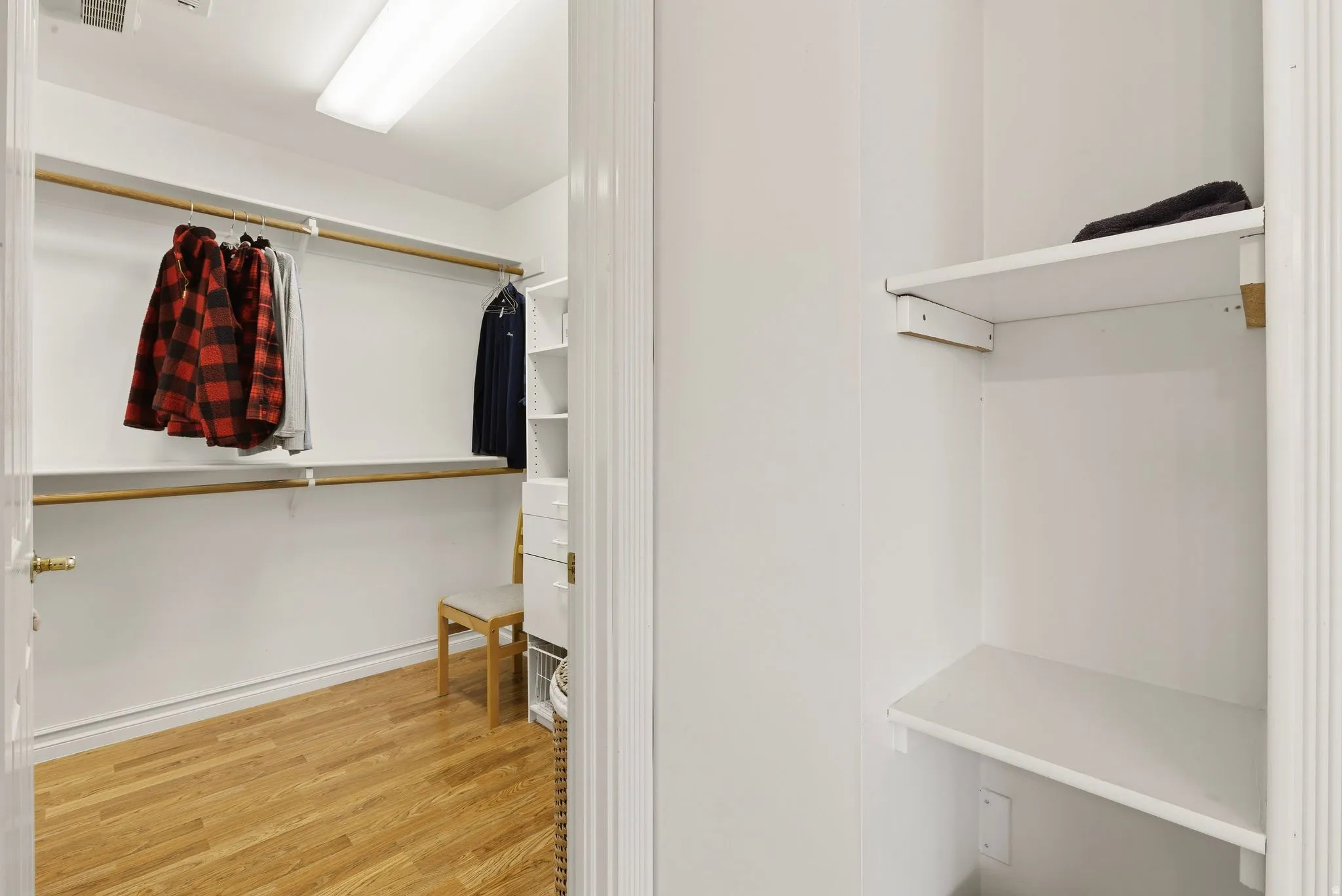 Walk in closet with light wood-style floors