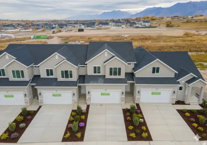 Craftsman-style house with stone siding, driveway, a mountain view, and an attached garage