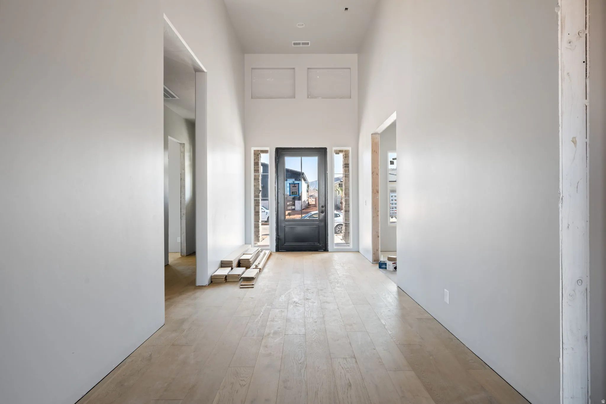 Corridor with a high ceiling and hardwood / wood-style floors
