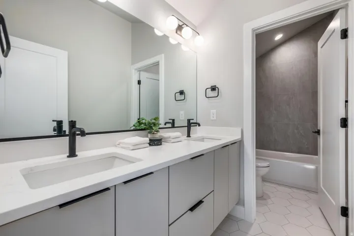 Dual vanity with integrated sinks, matte black fixtures, and a spacious mirror