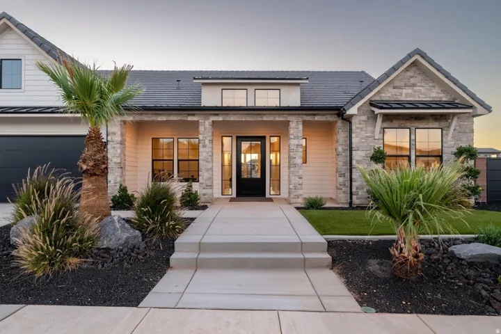 Modern exterior with stone accents, dark-framed windows, and a black front door