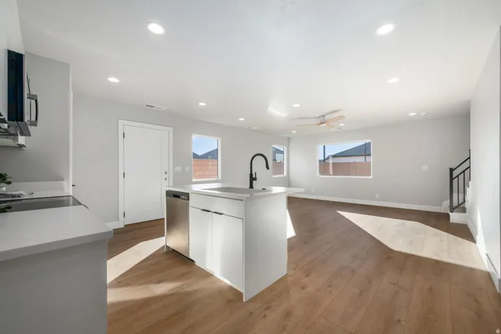 Open-concept living area featuring wood-finish flooring, recessed lighting, and a ceiling fan
