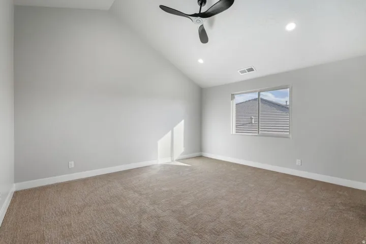 Vaulted ceiling with a black ceiling fan, recessed lighting, and a window with horizontal blinds