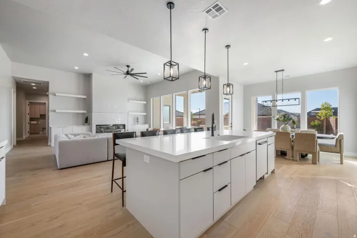 Kitchen island with white countertops, integrated sink, and modern pendant lighting
