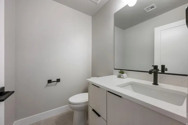 White rectangular sink with a matte black faucet, set into a light-toned vanity with black hardware