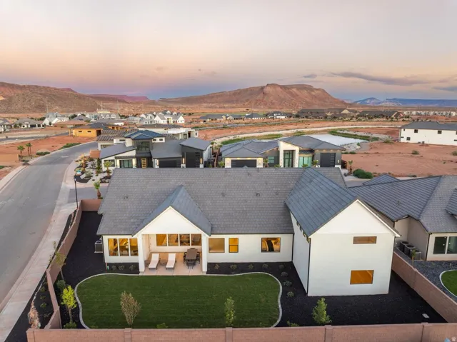 Expansive backyard featuring a manicured lawn, paved patio, and covered outdoor living space