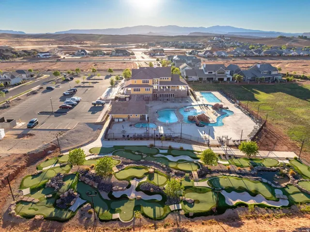 Outdoor recreation area featuring a miniature golf course, multiple swimming pools, and a community building with an expansive patio