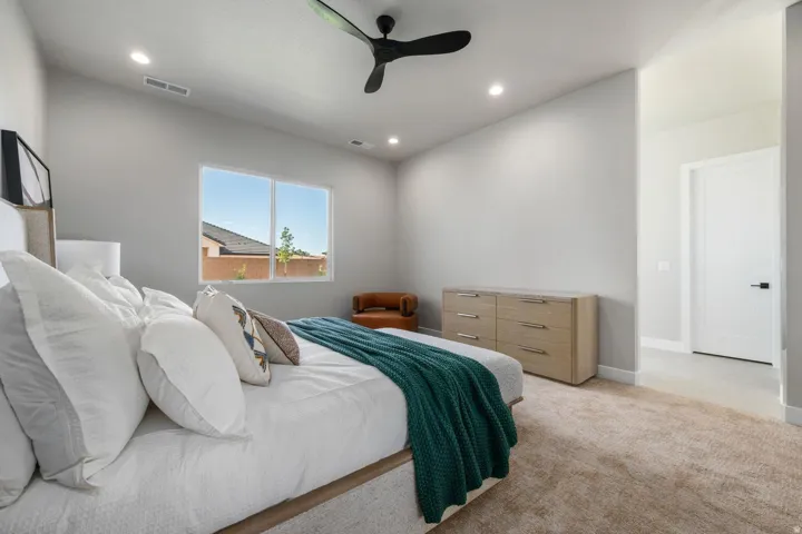 Recessed lighting, ceiling fan, dual windows, light-toned carpeting, and a white interior door with black hardware