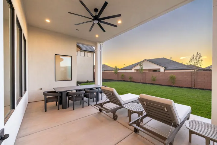 Covered patio with a large ceiling fan and recessed lighting