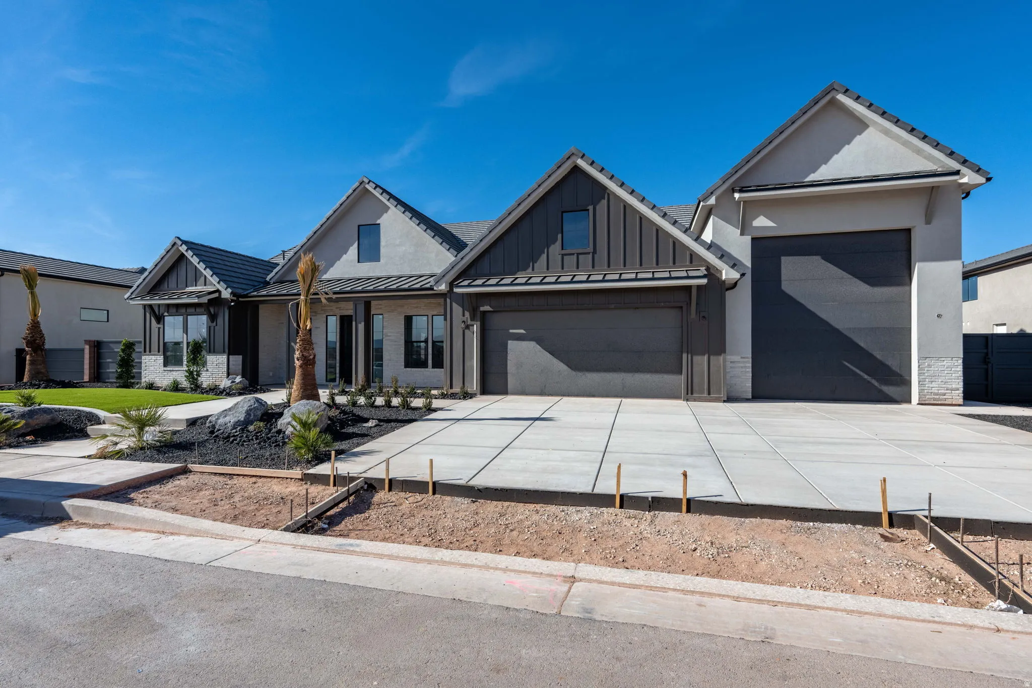 Modern inspired farmhouse featuring concrete driveway, a garage, board and batten siding, and covered porch