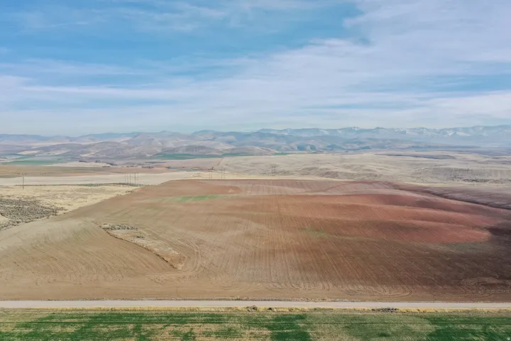 View of rural area with a mountain backdrop and abundant farmland