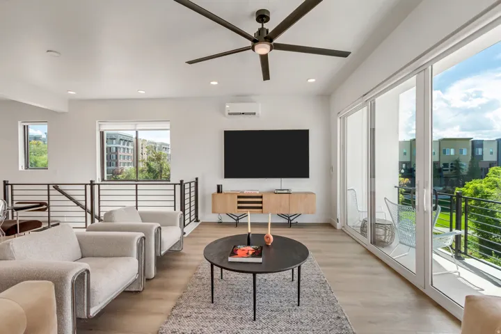 Living room with light wood finished floors, ceiling fan, and recessed lighting