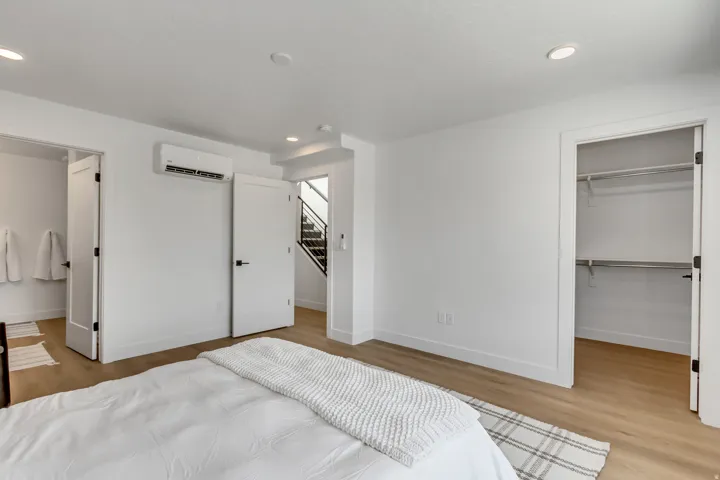 Bedroom featuring a walk in closet, light wood-type flooring, and recessed lighting