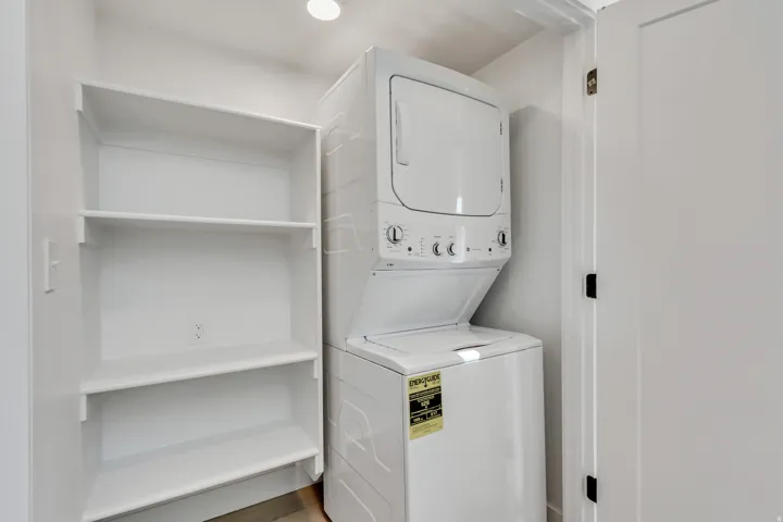 Laundry area with stacked washer and clothes dryer