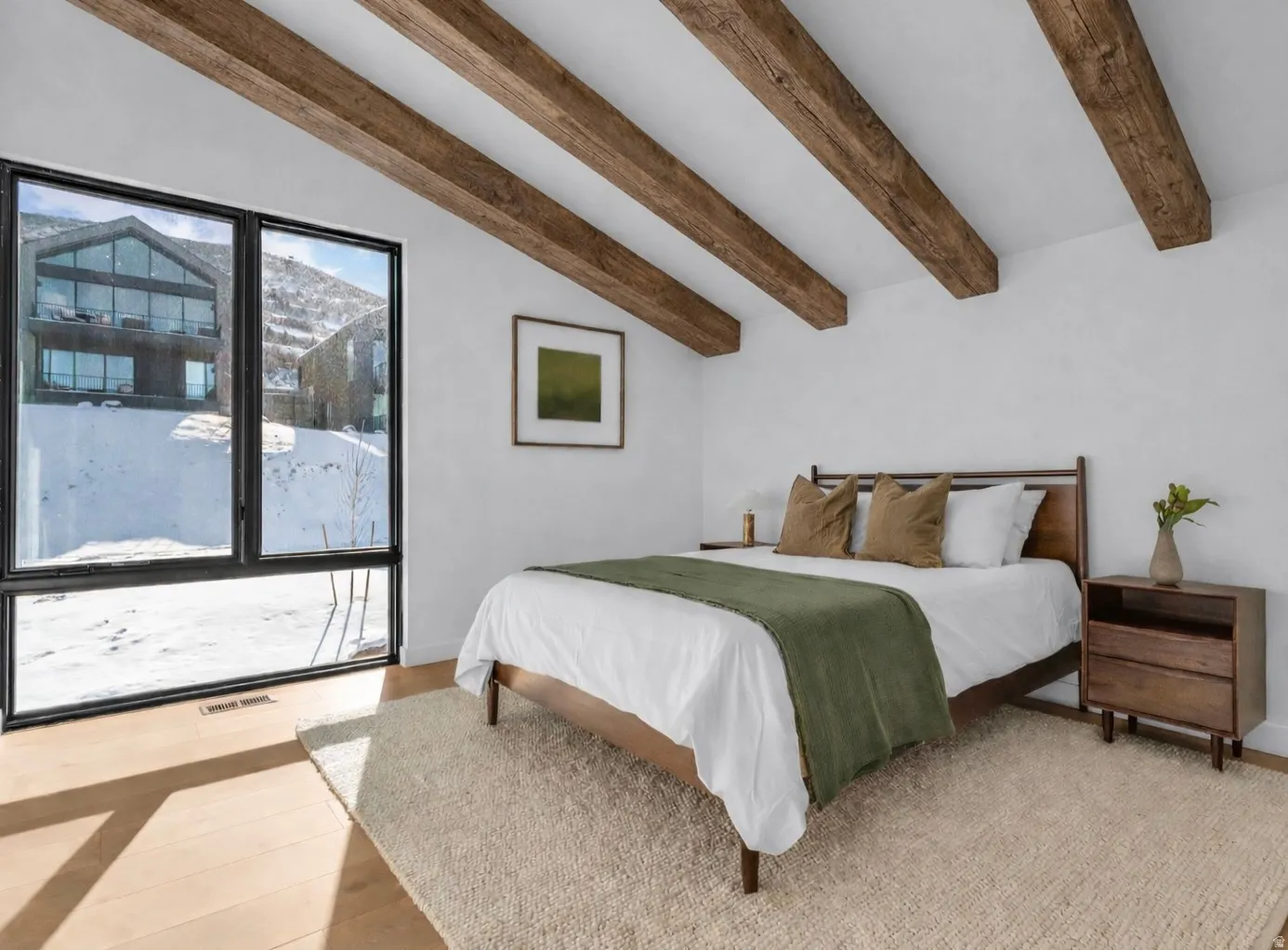 Bedroom featuring vaulted ceiling with beams and light wood-type flooring