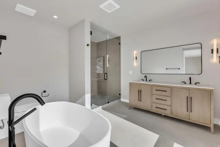 Full bathroom with a stall shower, double vanity, and a freestanding tub