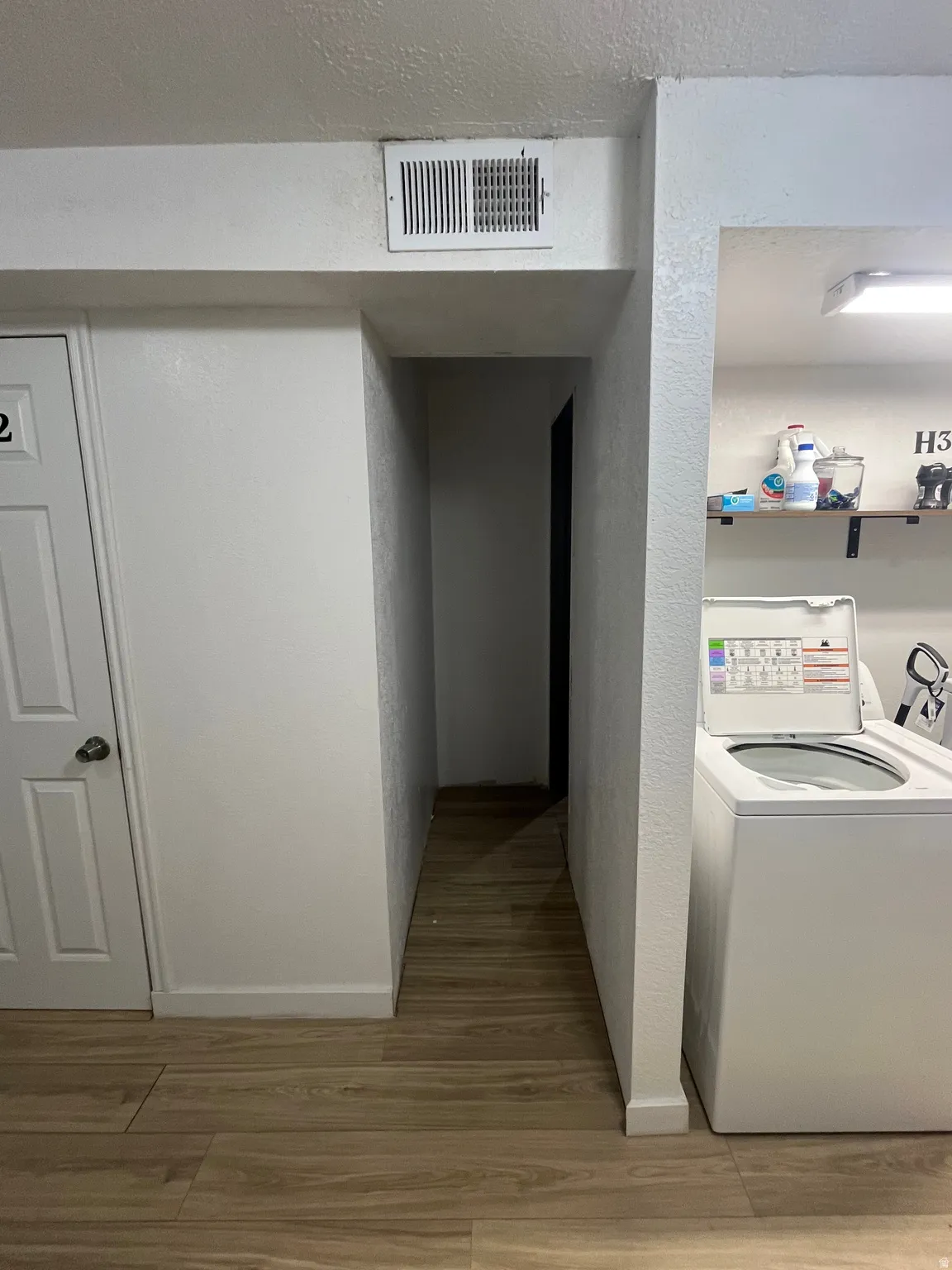 ADU Laundry  with narrow hallway between ADU and owners portion of basement.