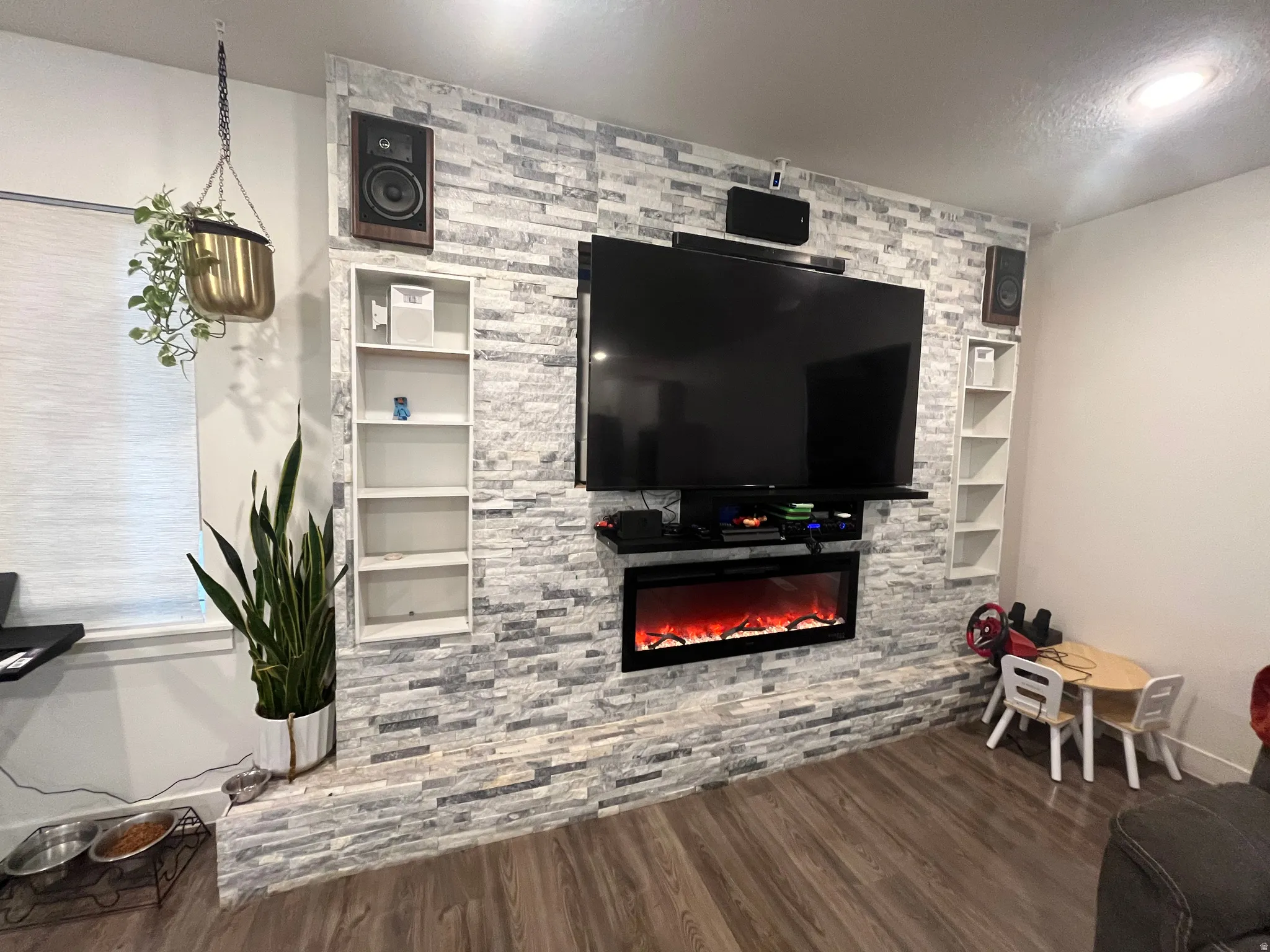 Living area featuring wood finished floors and a stone fireplace