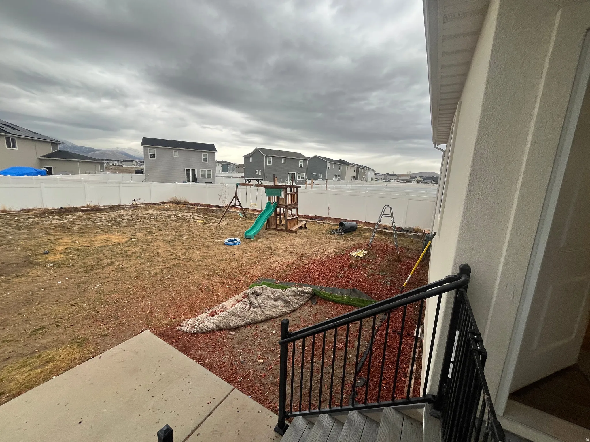 Fenced backyard with a playground and a residential view