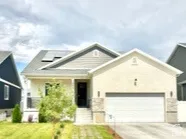View of front of home featuring concrete driveway, a garage, a porch, solar panels, and stucco siding