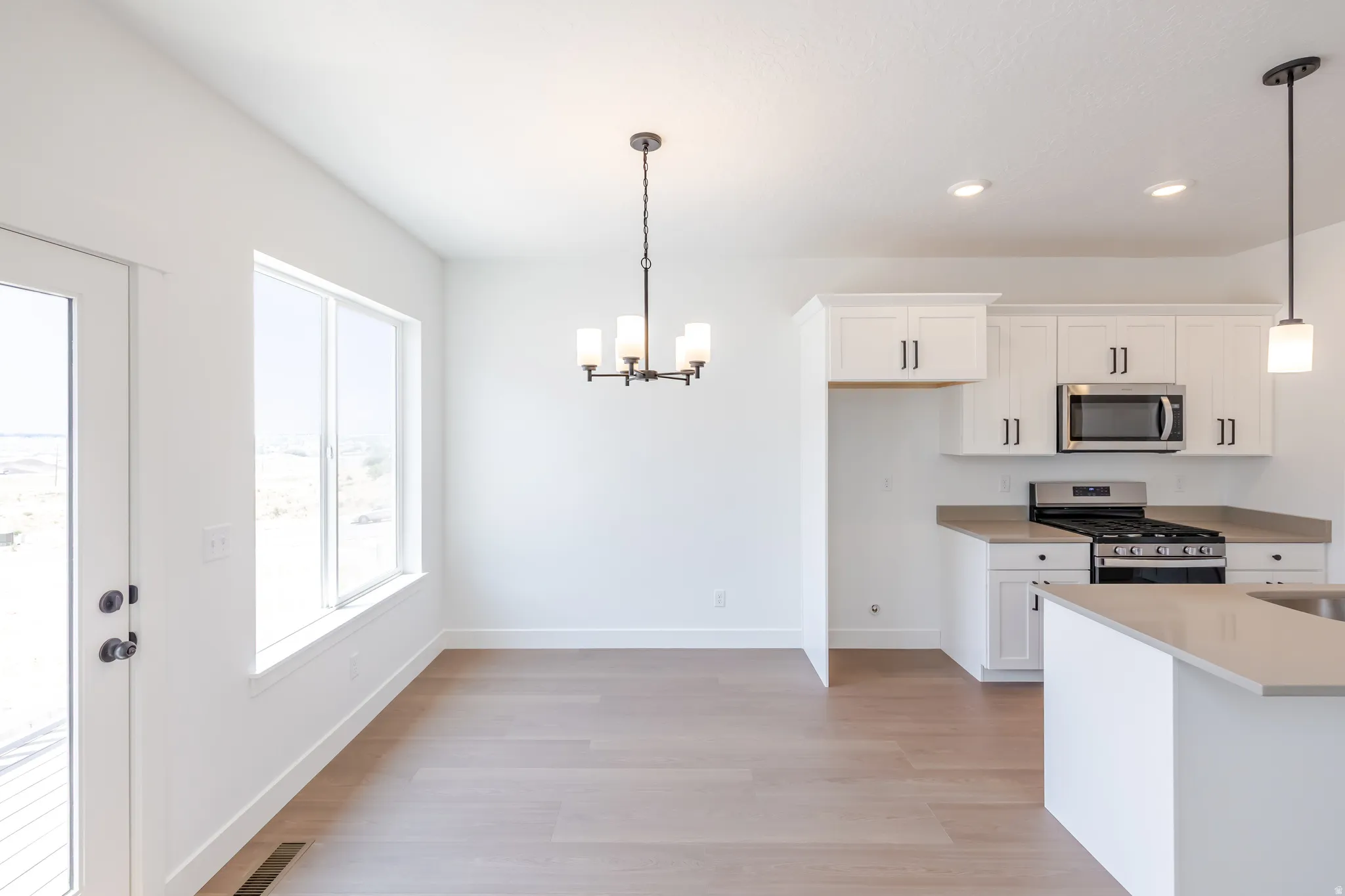 Open concept kitchen and dining area featuring light wood-finish flooring