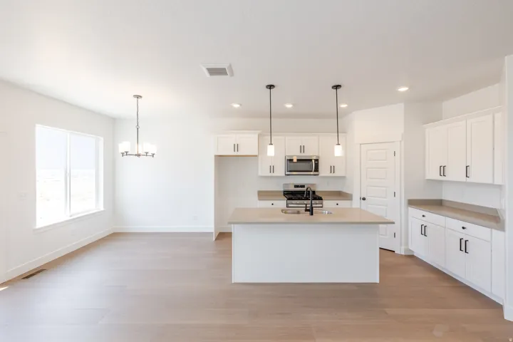 Open-concept kitchen and dining area with light wood-finish flooring