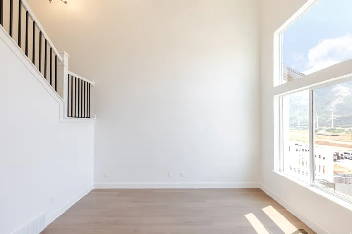 Two-story living area with high ceilings and wood-finish flooring