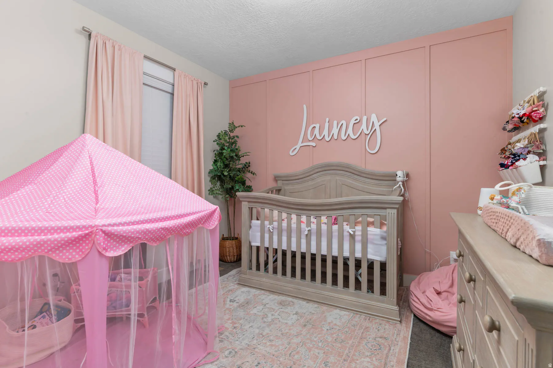 Bedroom featuring a nursery area and a textured ceiling