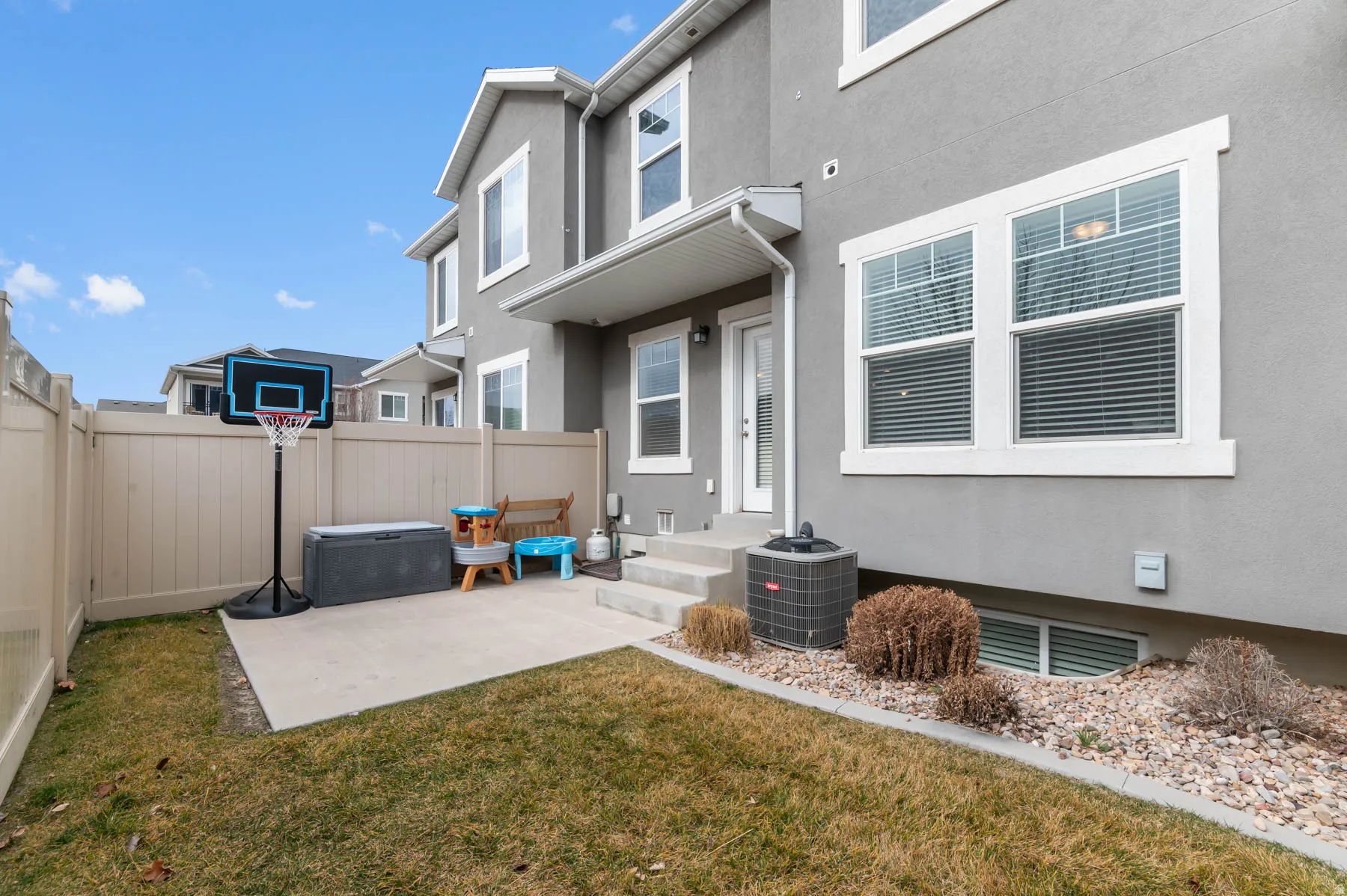 Rear view of property featuring stucco siding and a fenced backyard