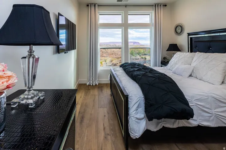 Bedroom with dark wood-style flooring and baseboards