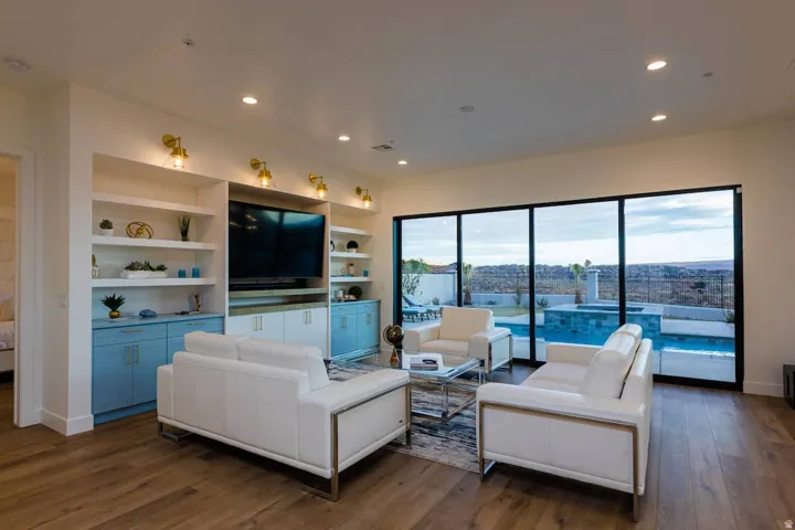 Living area featuring dark wood-style flooring, recessed lighting, and built in shelves