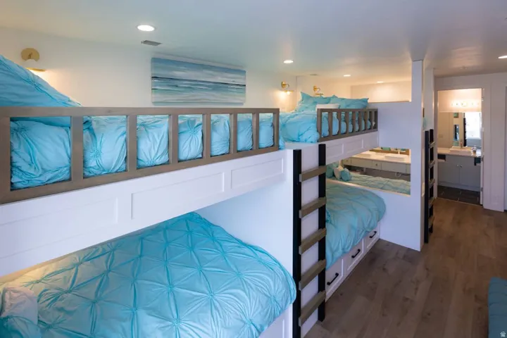 Bedroom with dark wood finished floors, recessed lighting, and ensuite bathroom