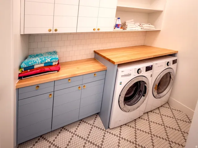 Laundry room with washer and clothes dryer, cabinet space, and light tile patterned floors