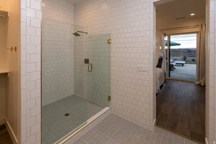 Ensuite bathroom with a shower stall, recessed lighting, and dark wood-style floors