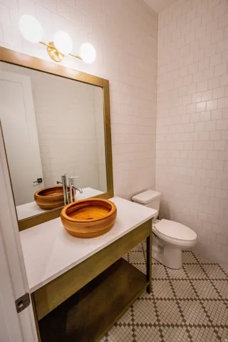 Half bath featuring tile walls, vanity, and tile patterned floors