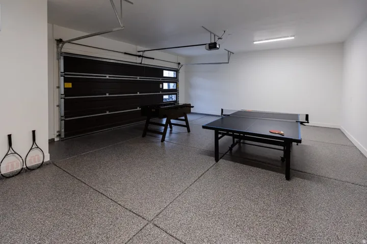 Garage featuring baseboards and a garage door opener