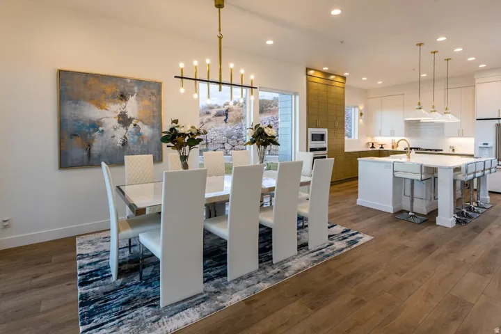 Dining space featuring dark wood-style flooring and suspended lighting
