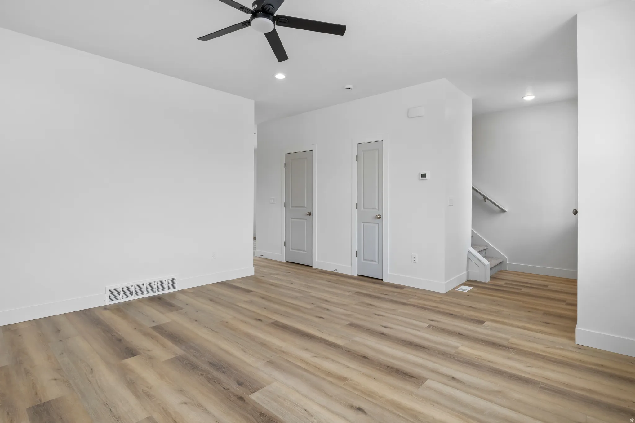Unfurnished living room featuring a ceiling fan, light wood-style flooring, and recessed lighting