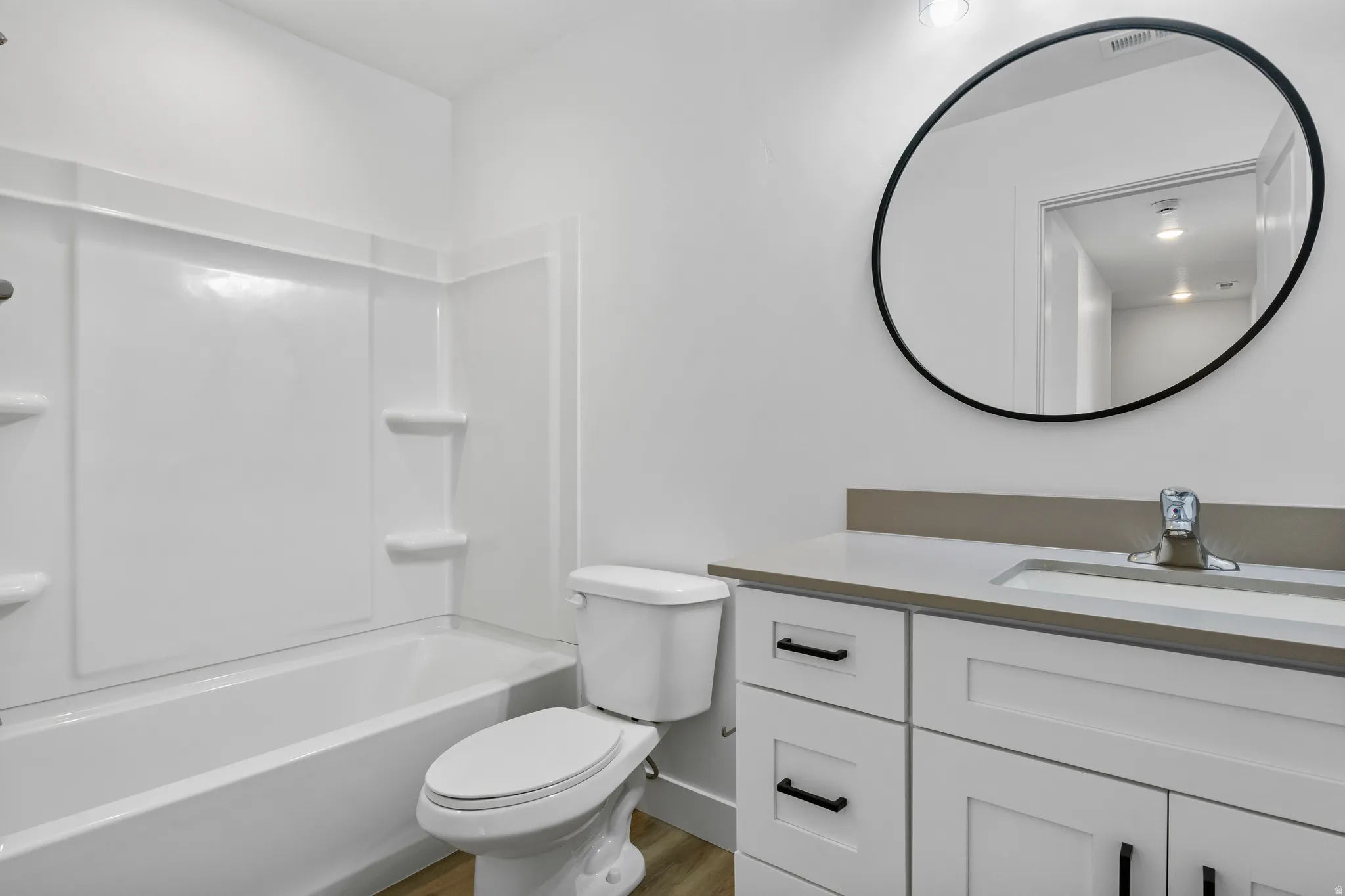 Full bath with vanity, shower / tub combination, and light wood-style floors
