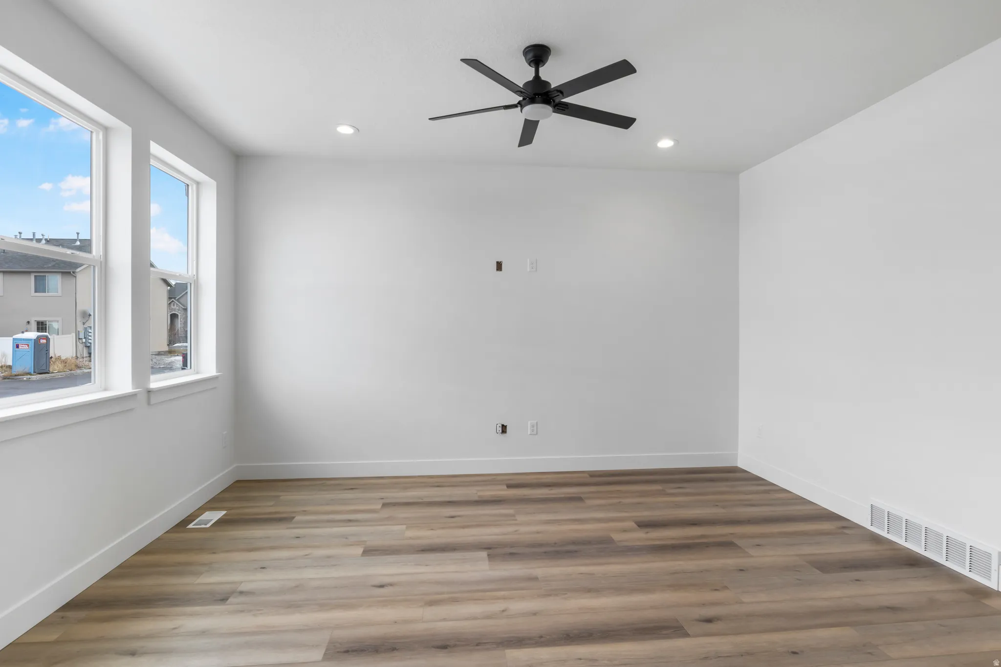 Unfurnished room featuring a ceiling fan, wood finished floors, and recessed lighting
