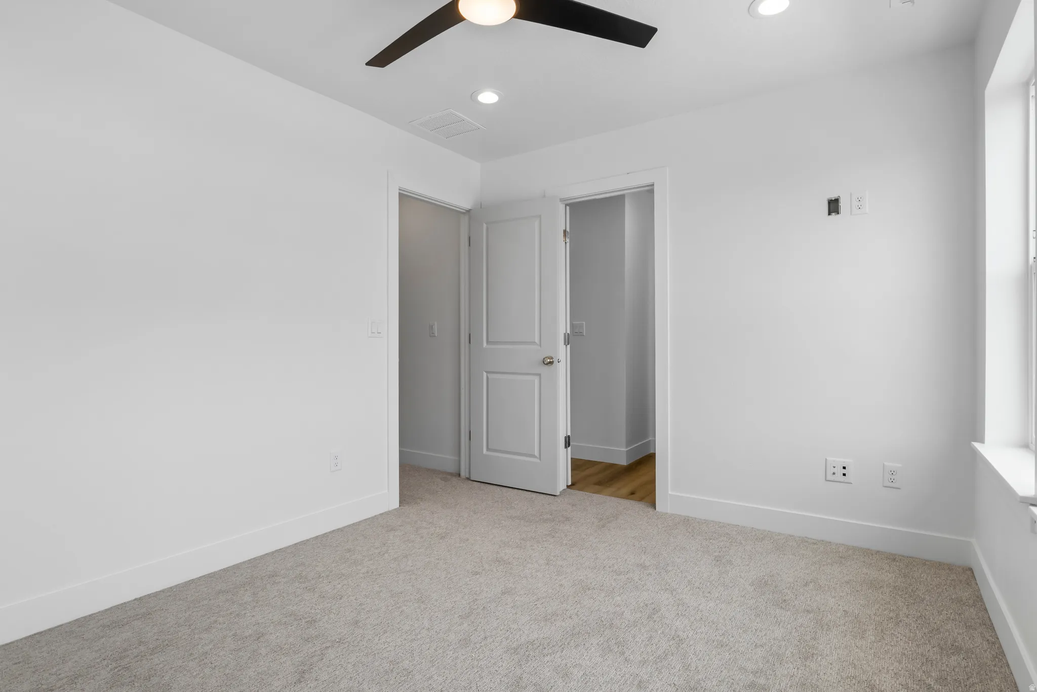 Unfurnished bedroom with light colored carpet, recessed lighting, and ceiling fan