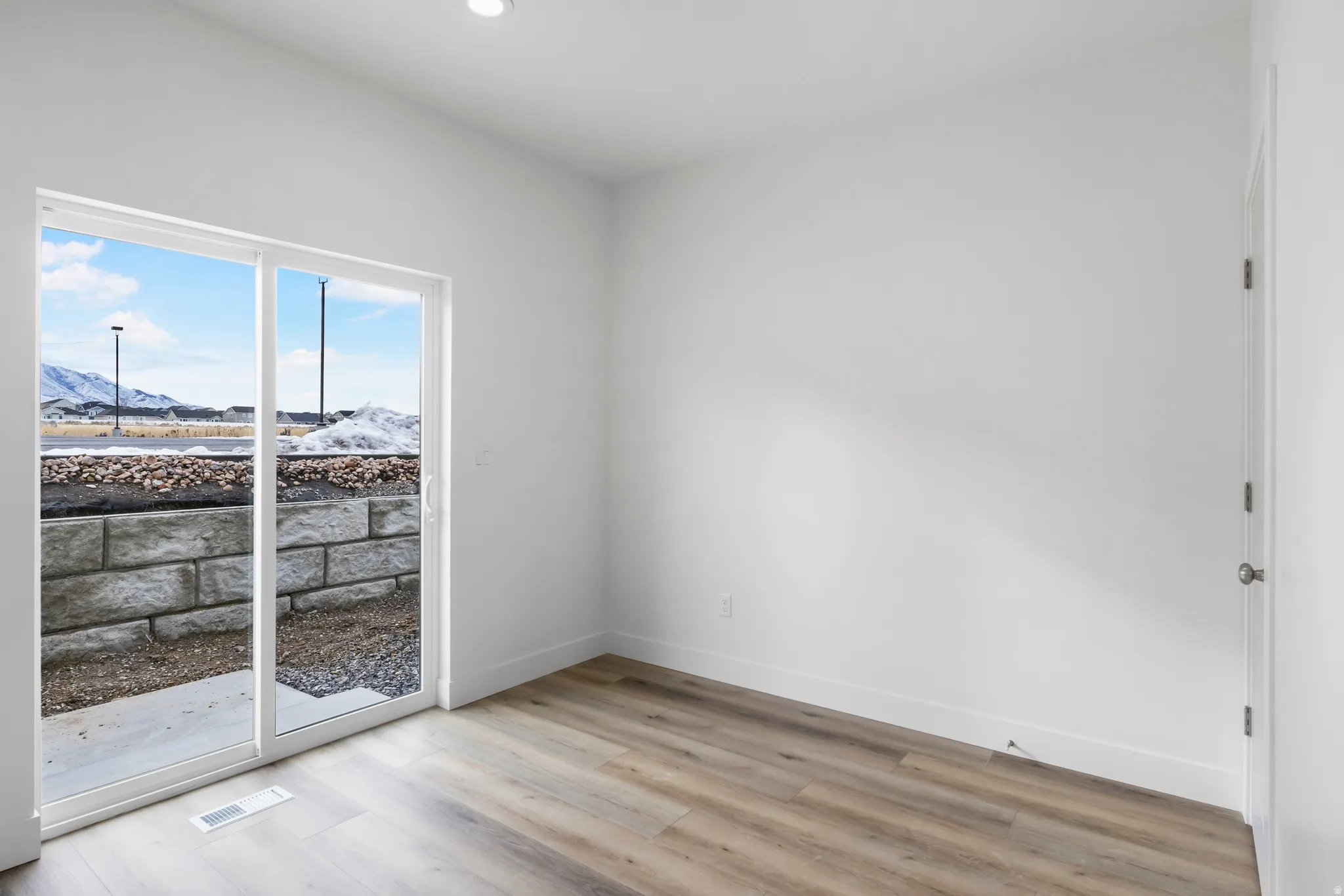 Unfurnished room with a mountain view, light wood-type flooring, and recessed lighting