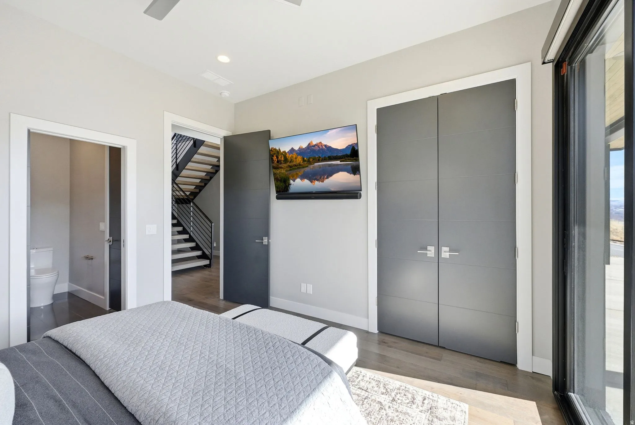 Bedroom with a closet, a ceiling fan, wood finished floors, connected bathroom, and recessed lighting