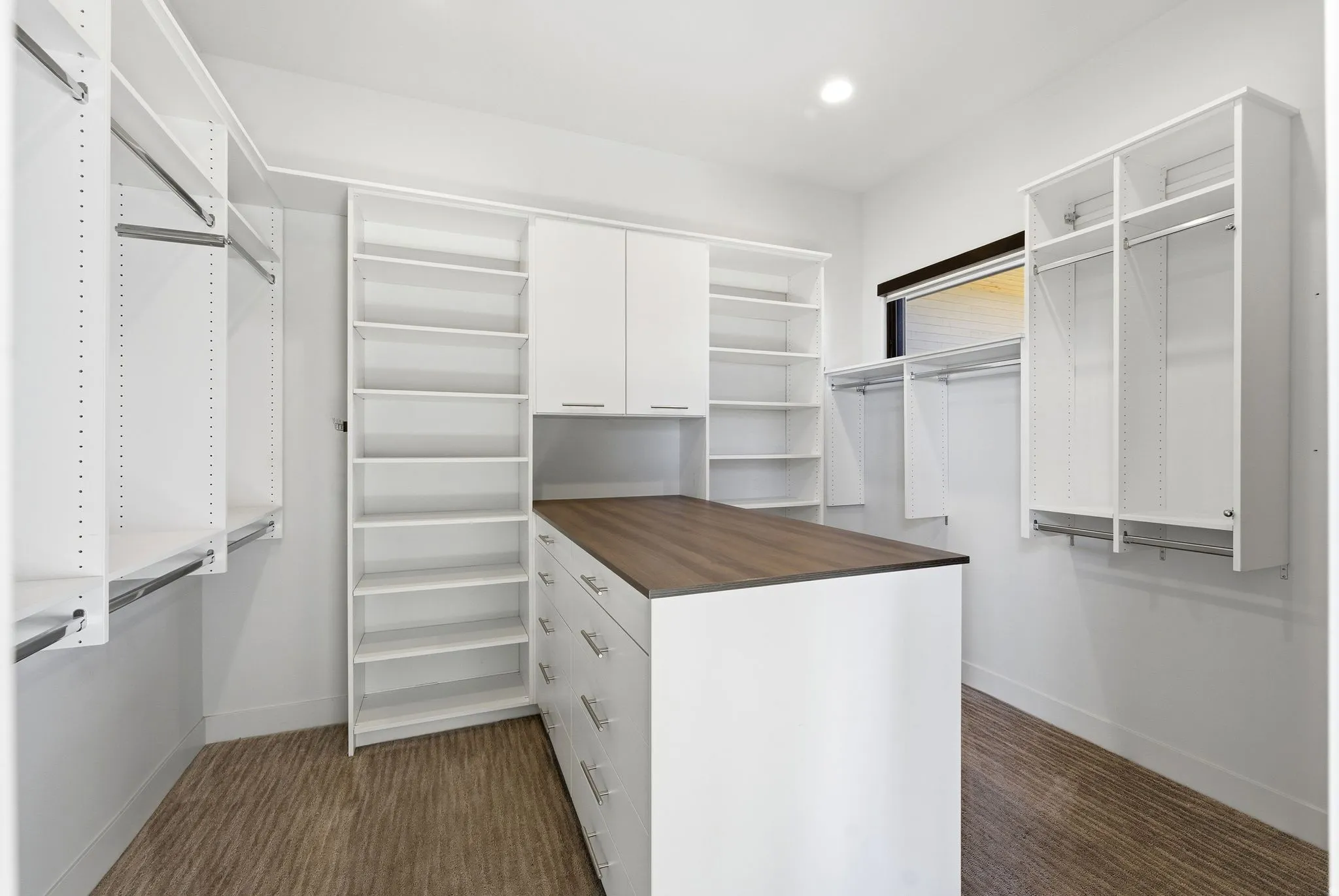 Walk in closet with dark colored carpet